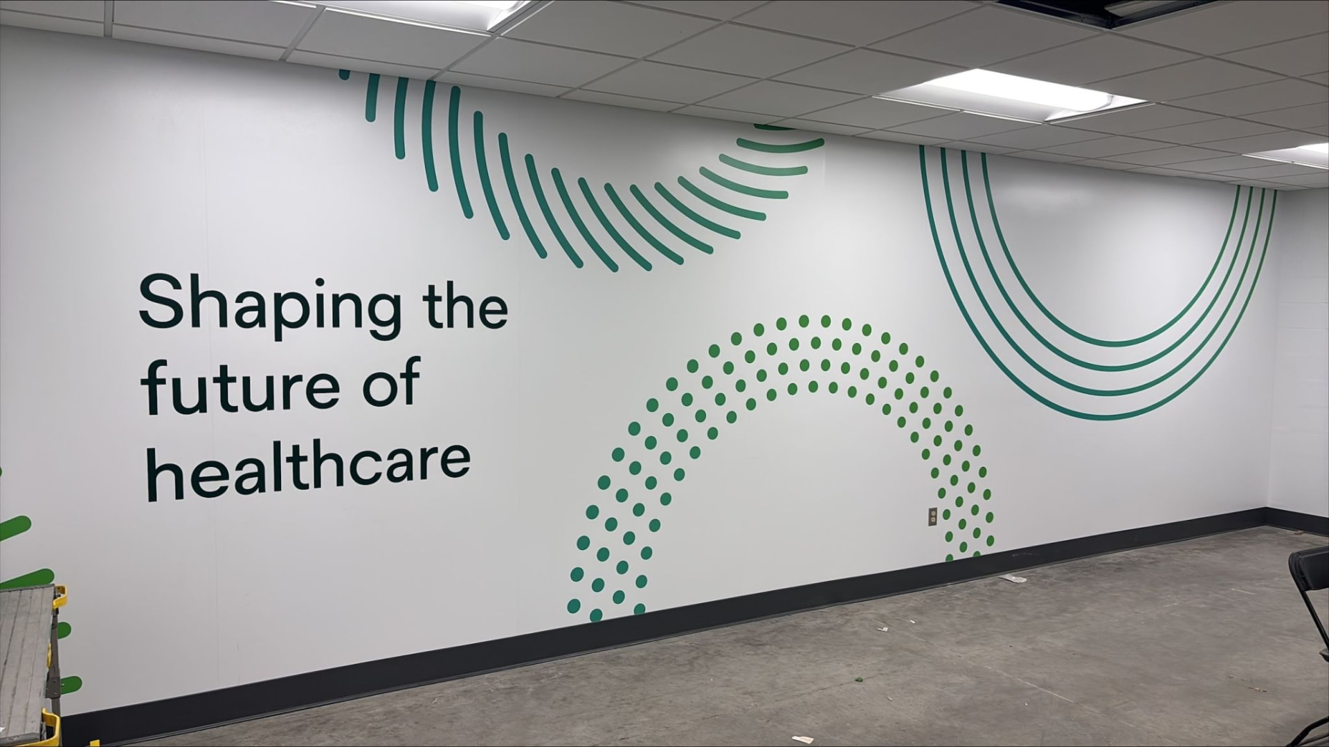 Solventum branded interior environmental graphics with teal dot and line patterns on a white wall.