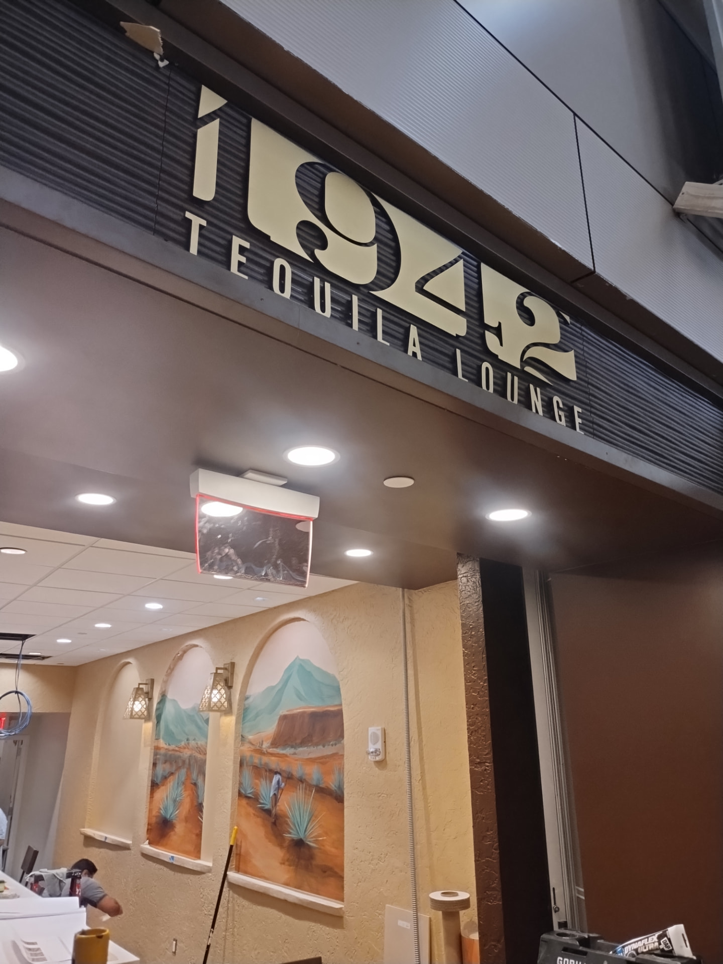 1942 Tequila Lounge dimensional lettering mounted on a dark corrugated fascia above the bar