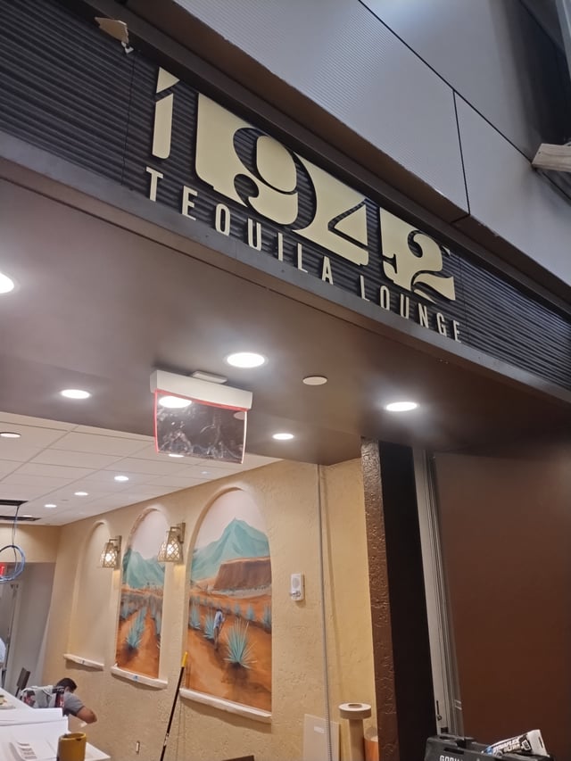 1942 Tequila Lounge dimensional lettering mounted on a dark corrugated fascia above the bar