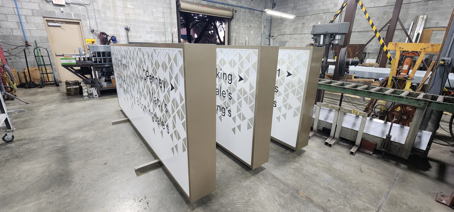 Multi-tenant retail directory signs staged in the AIS shop, kitted and ready for field installation