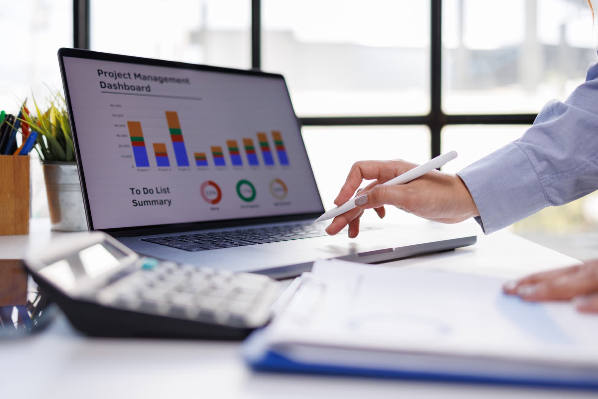 Project manager reviewing a real-time project management dashboard on a laptop