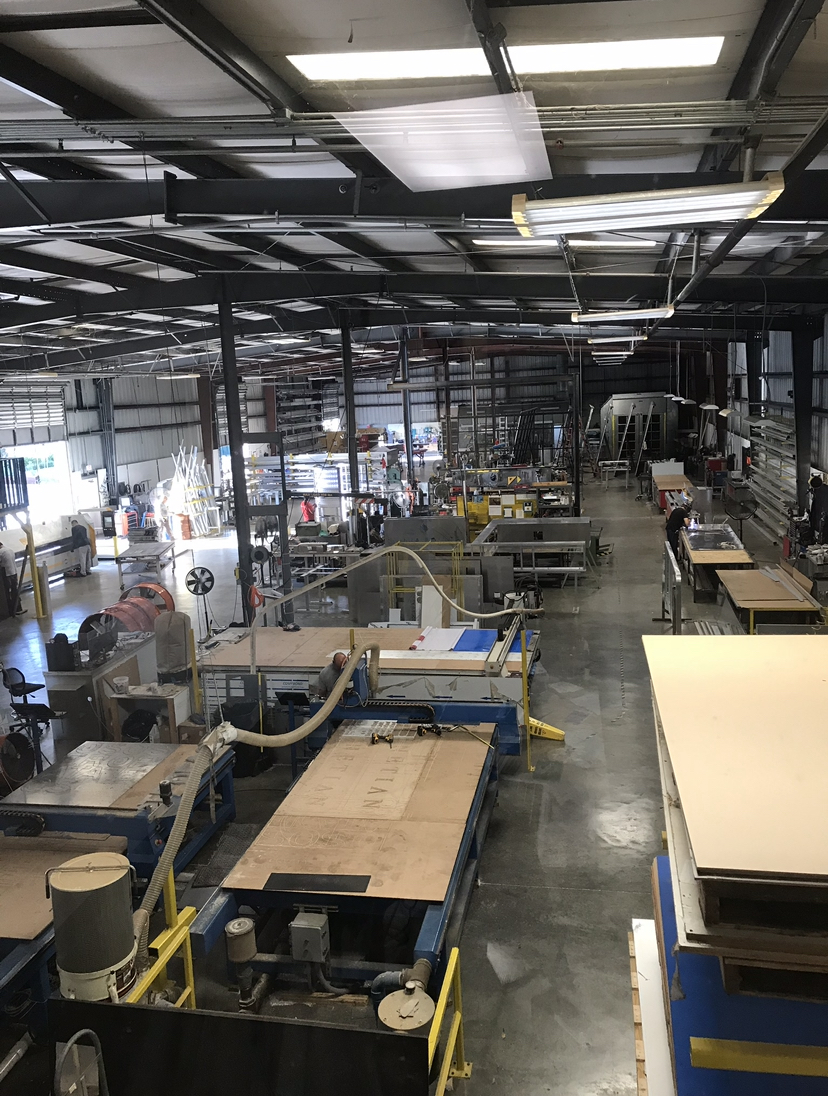 AIS Boynton Beach manufacturing shop floor with fabrication equipment and signage in production