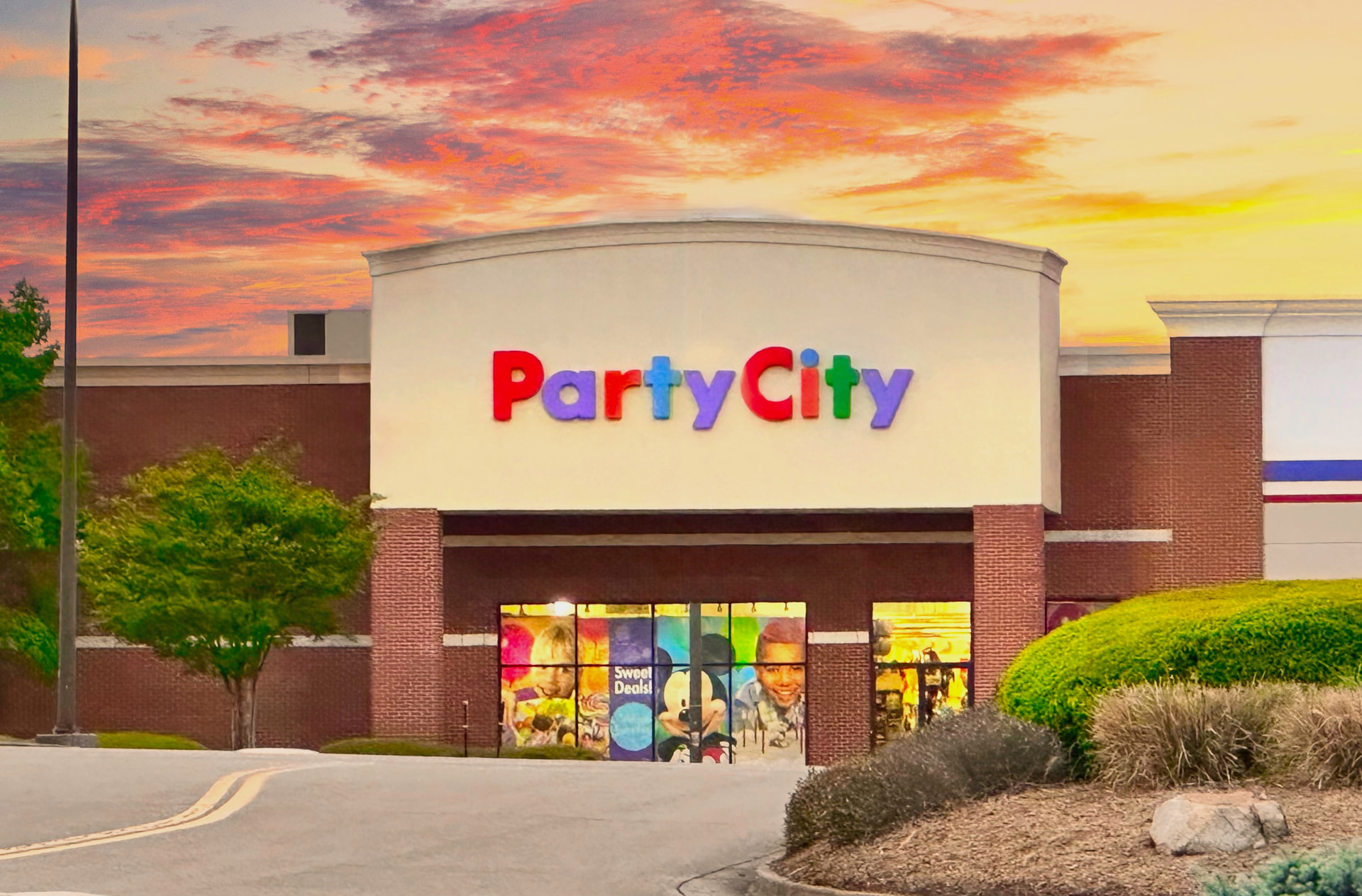 Party City storefront with branded signage at sunset