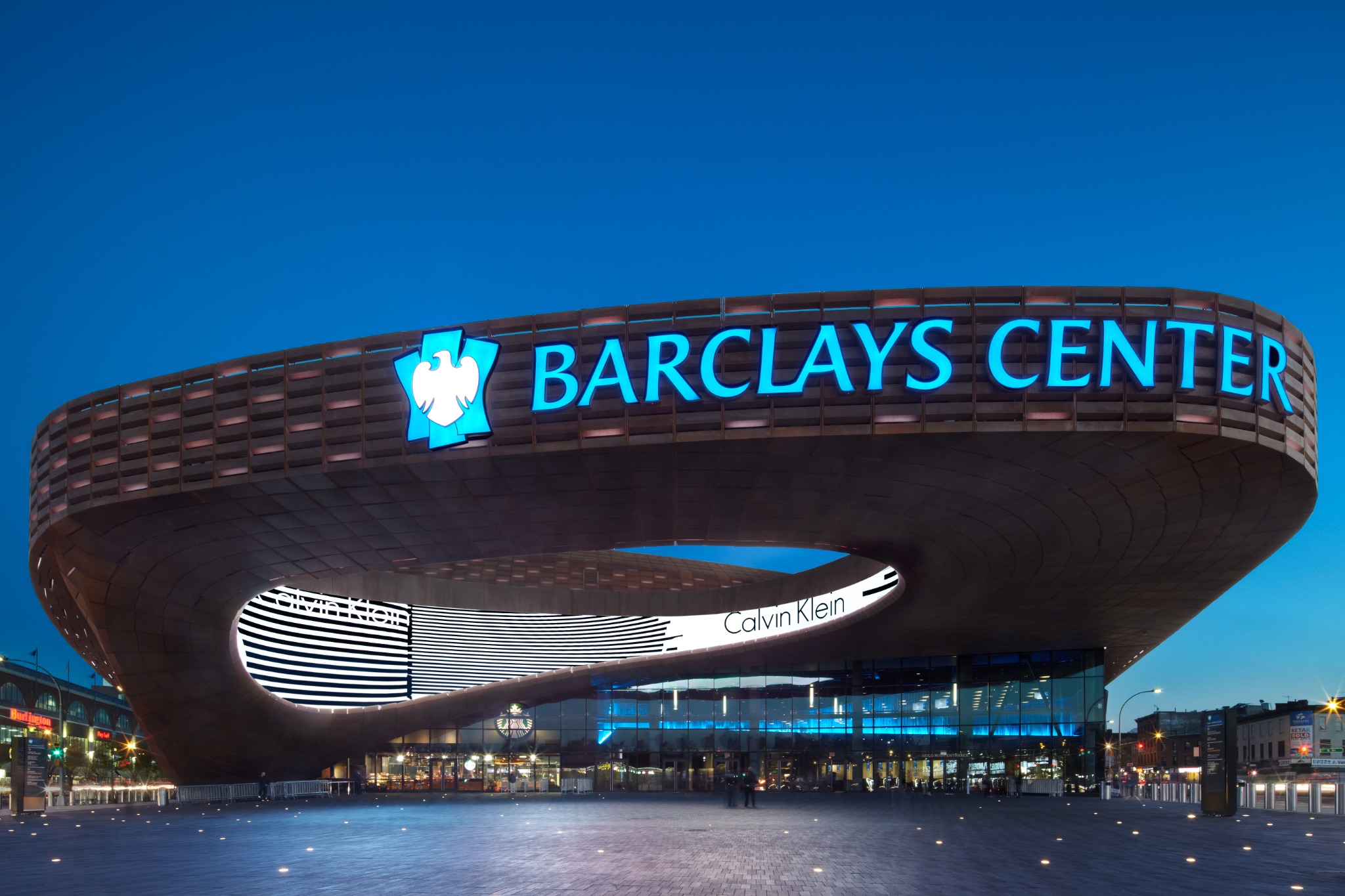 Illuminated Barclays Center exterior identification signage at dusk