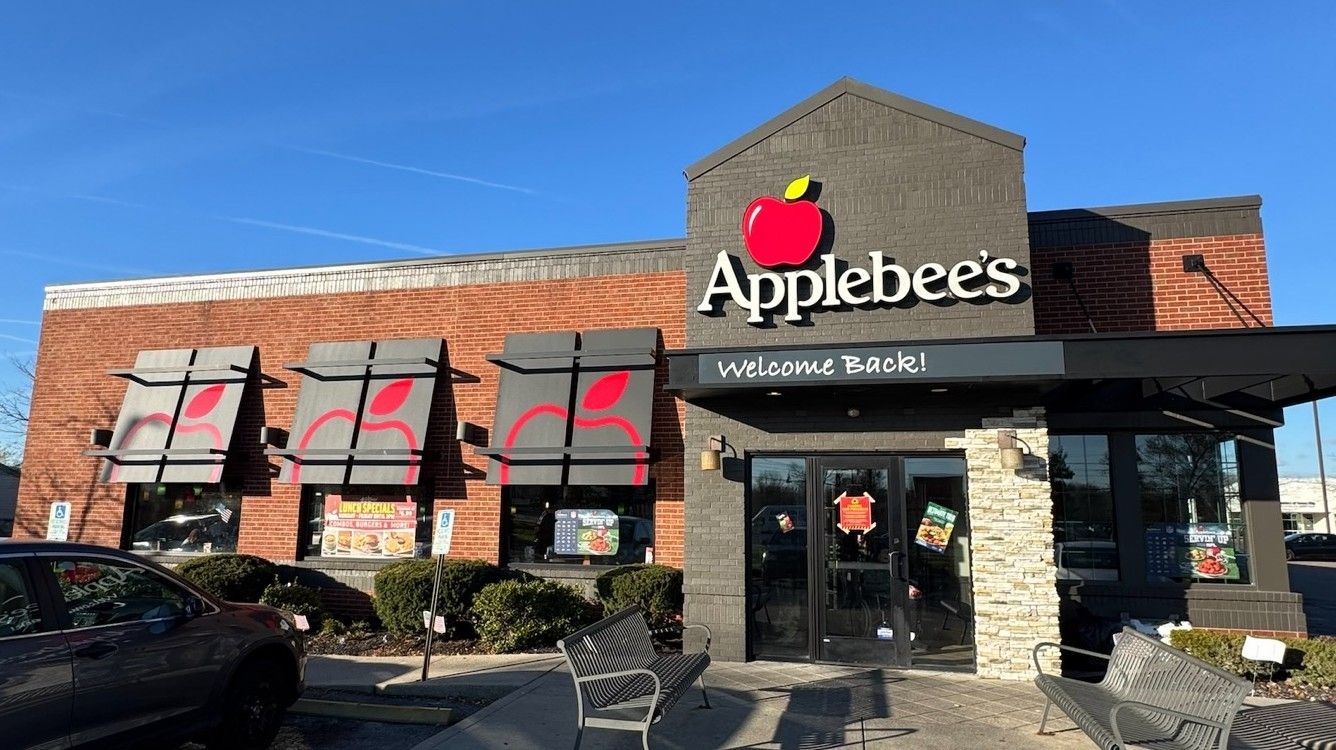 Applebee's restaurant storefront with illuminated apple logo channel letters, awnings, and a Welcome Back! entrance canopy