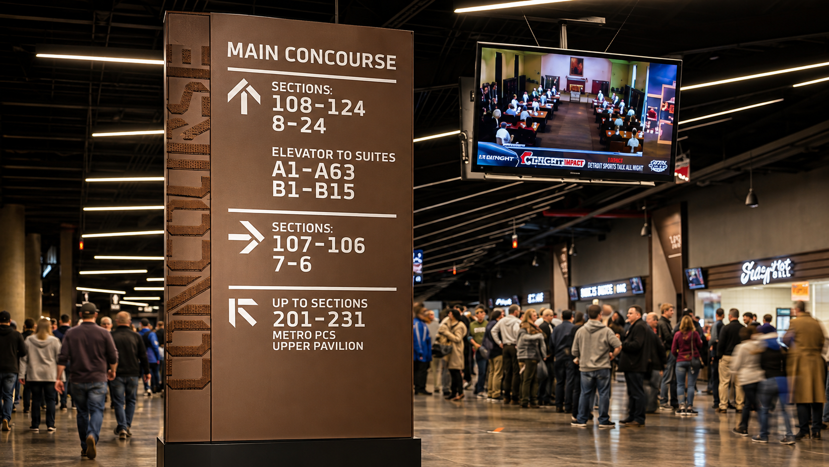 Main concourse directory and wayfinding totem in a busy arena with section, suite, and elevator directions