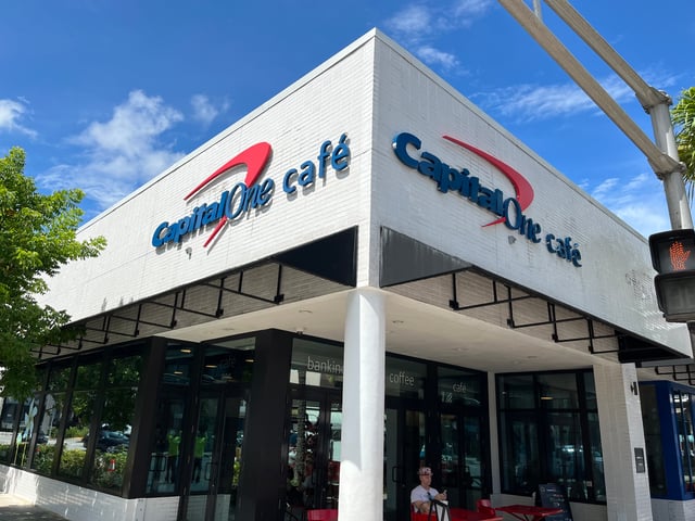 Exterior Capital One Café identification signage on a white brick building