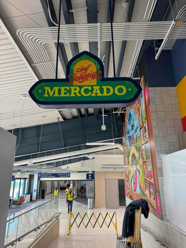 Chef Johnny's Mercado illuminated hanging blade sign in an airport concourse