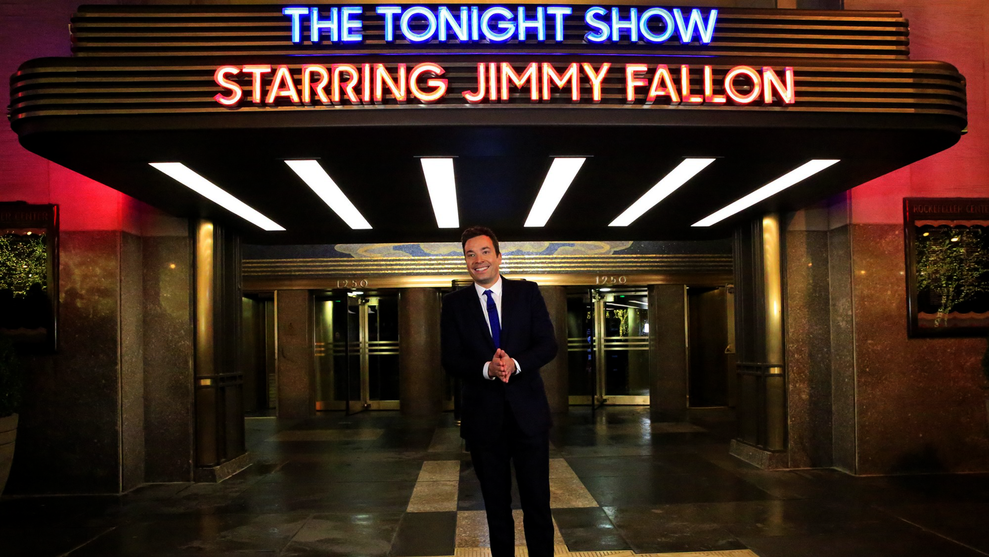 Illuminated theater marquee reading The Tonight Show Starring Jimmy Fallon above a lobby entrance