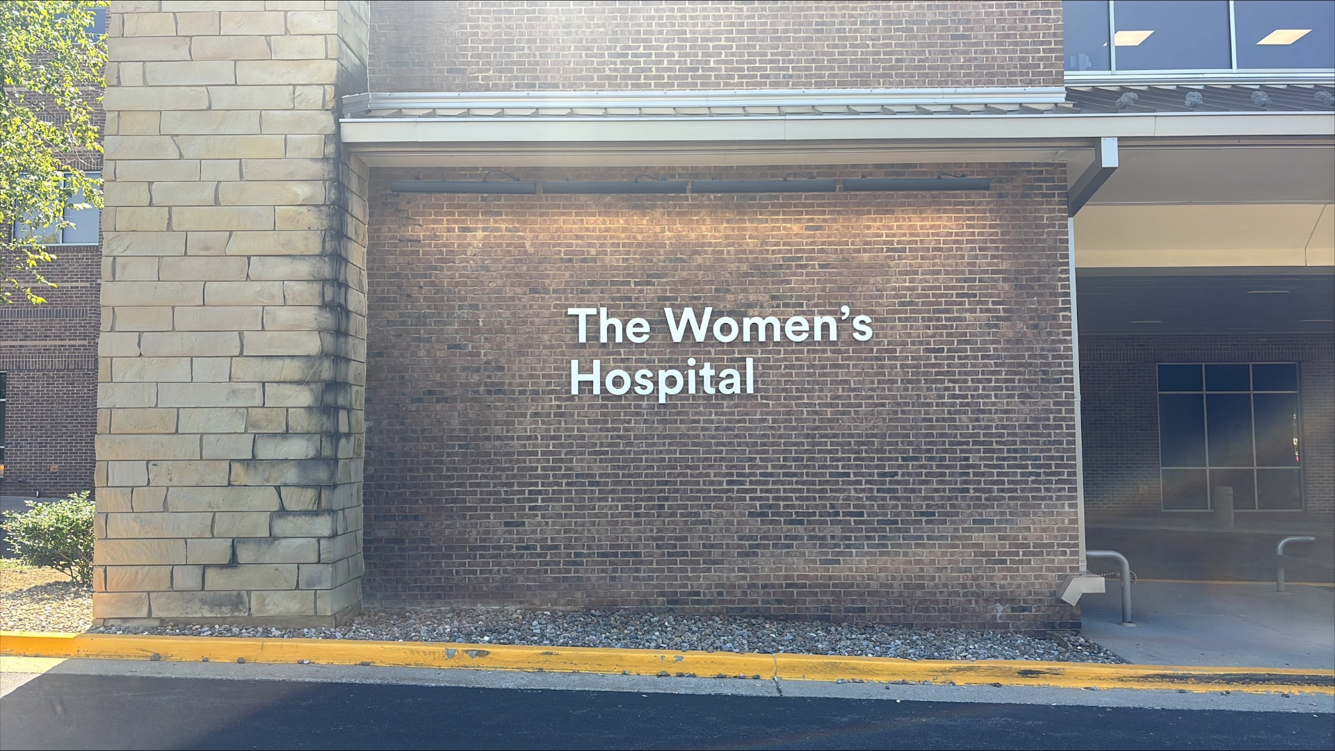 The Women's Hospital white dimensional letters mounted on a brick exterior wall near the entrance