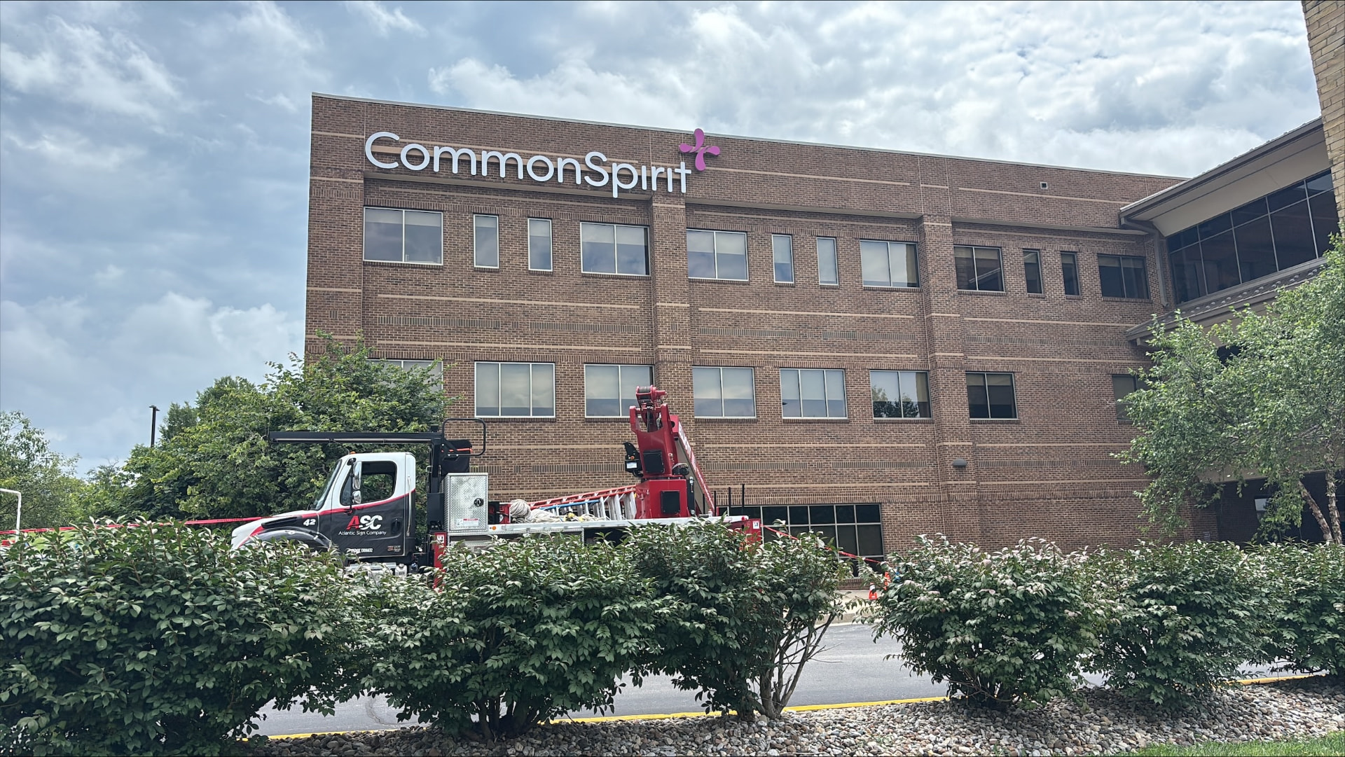 CommonSpirit brick office building with AIS installation truck in foreground