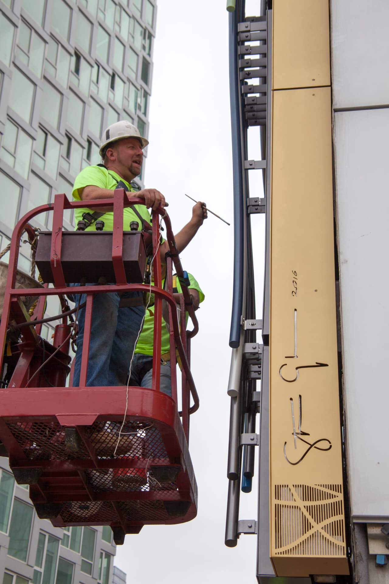 AIS installation crew setting exterior signage on a commercial building