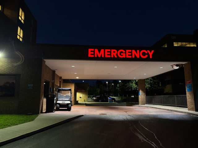 Red illuminated EMERGENCY channel letters glowing above a hospital entrance canopy at night